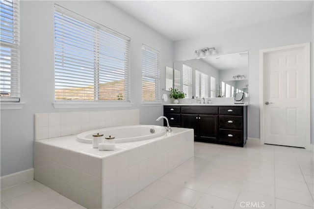 full bath featuring vanity, tile patterned flooring, baseboards, and a garden tub