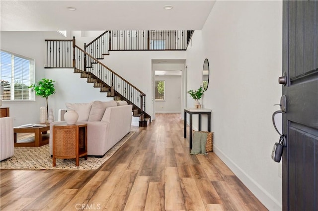 entryway with baseboards, plenty of natural light, and light wood finished floors
