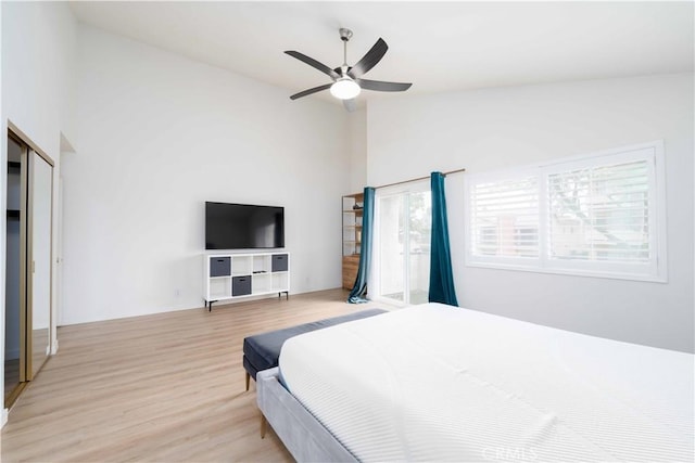 bedroom with ceiling fan, light wood-style flooring, and lofted ceiling
