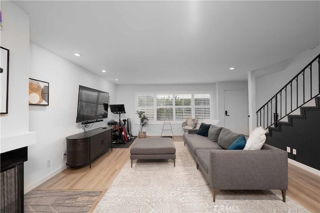 living area with light wood-style floors, baseboards, stairway, and recessed lighting