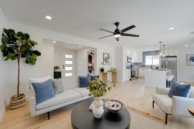living room featuring a ceiling fan, recessed lighting, light wood-style flooring, and visible vents