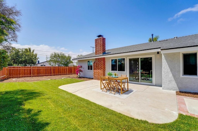 rear view of property with a lawn, a patio, fence, and a chimney
