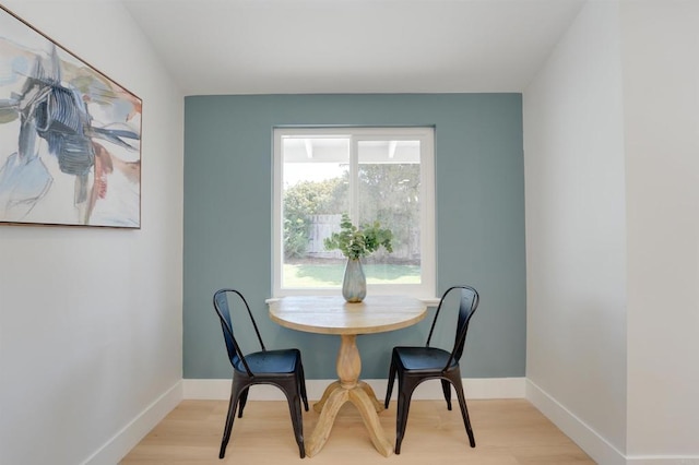 dining area featuring baseboards and light wood finished floors