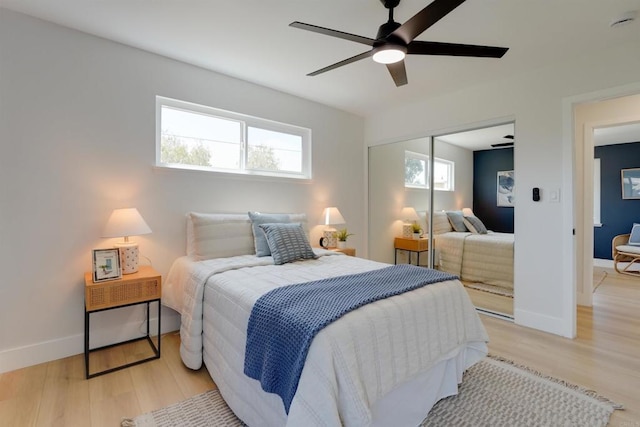 bedroom featuring baseboards, ceiling fan, light wood finished floors, and a closet