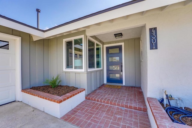 entrance to property featuring board and batten siding and stucco siding