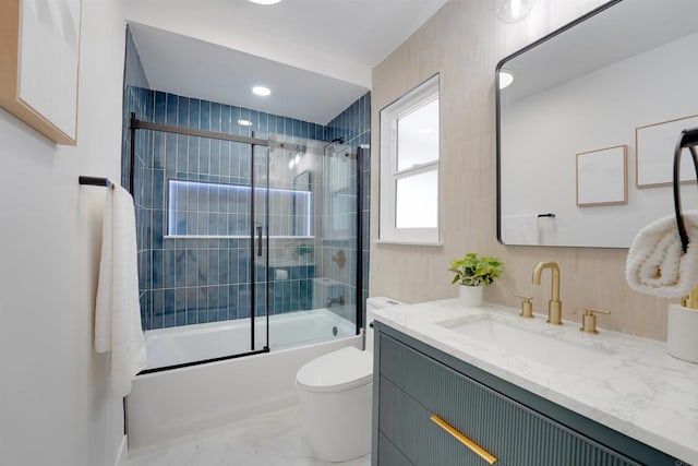 bathroom with vanity, combined bath / shower with glass door, toilet, marble finish floor, and recessed lighting