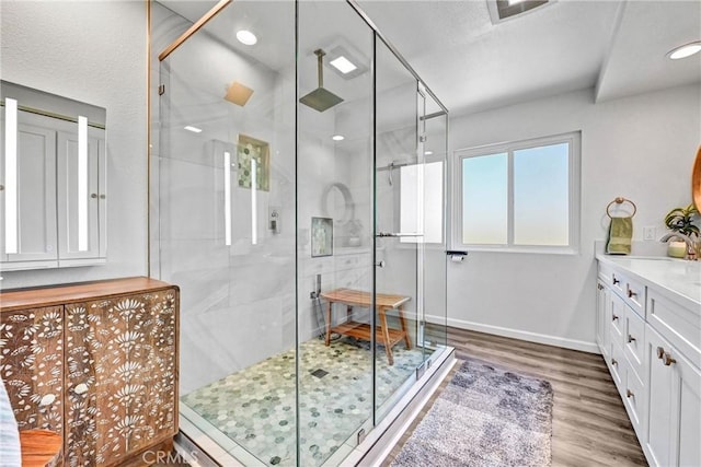 full bathroom with baseboards, a shower stall, wood finished floors, and vanity