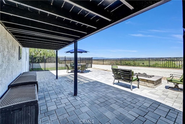 view of patio / terrace with a fenced backyard, outdoor dining space, and a fire pit