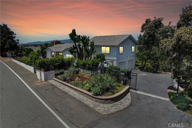 view of front facade with a garage, fence, a gate, and driveway
