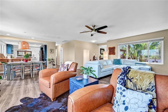 living room with a ceiling fan and wood finished floors