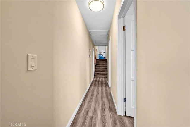 corridor with baseboards and wood finished floors