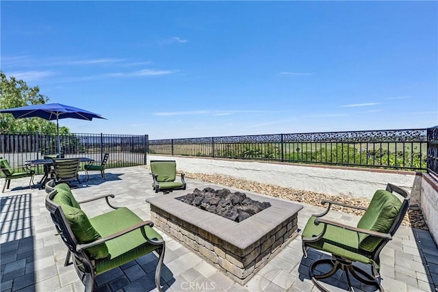 view of patio featuring a fenced backyard and a fire pit