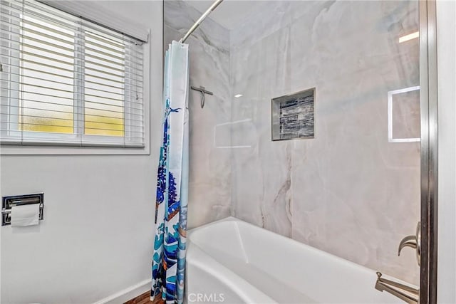full bath featuring baseboards and shower / bath combo