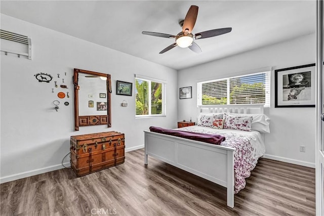 bedroom featuring a ceiling fan, baseboards, and wood finished floors