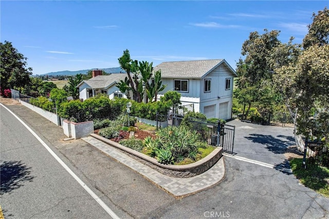 view of front of home with fence, driveway, and a garage