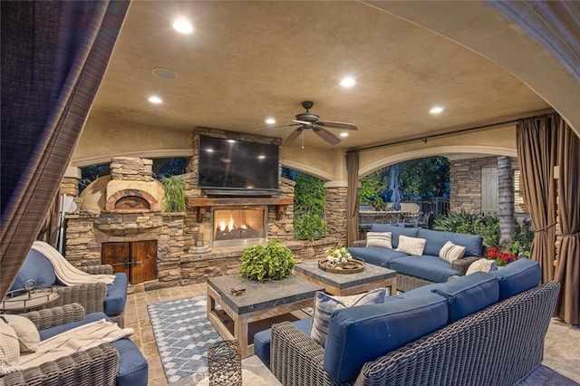 view of patio / terrace featuring a ceiling fan and an outdoor living space with a fireplace