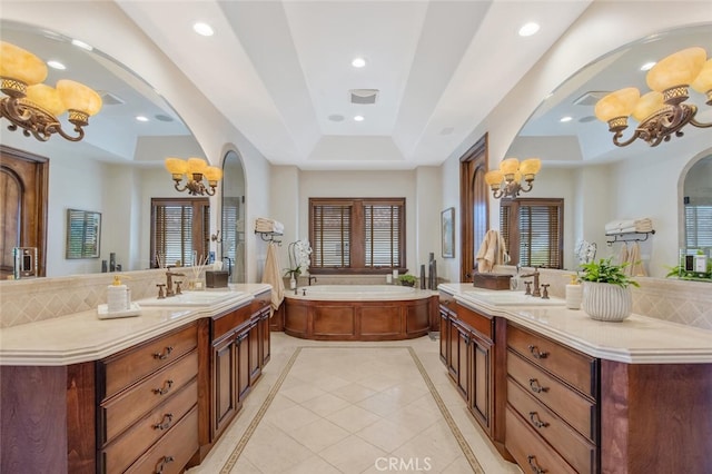 full bathroom featuring a sink, a tray ceiling, recessed lighting, and a notable chandelier