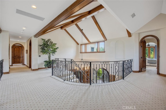 hall with visible vents, arched walkways, carpet floors, and an upstairs landing