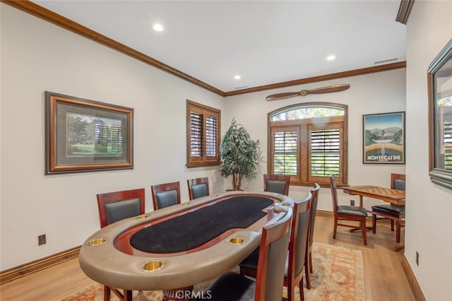 dining room featuring crown molding, recessed lighting, baseboards, and light wood-style floors