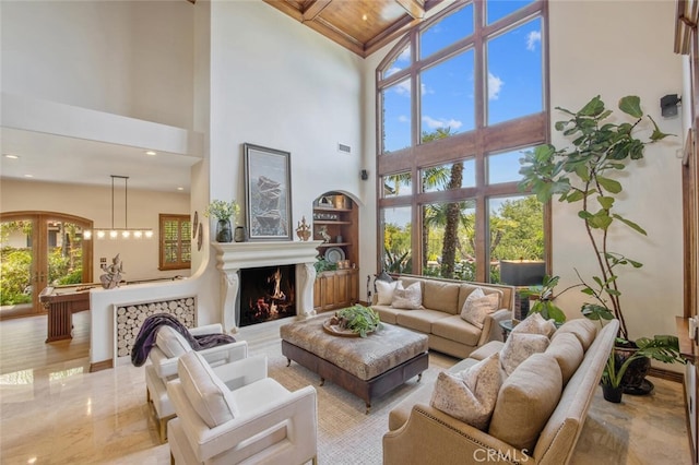 living room featuring a warm lit fireplace, high vaulted ceiling, french doors, and beamed ceiling