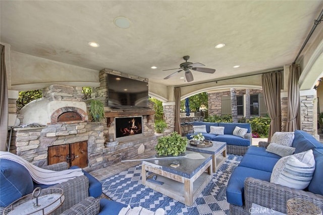 view of patio / terrace featuring a ceiling fan and an outdoor living space with a fireplace