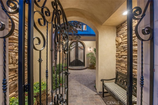 entrance to property featuring a gate and stucco siding