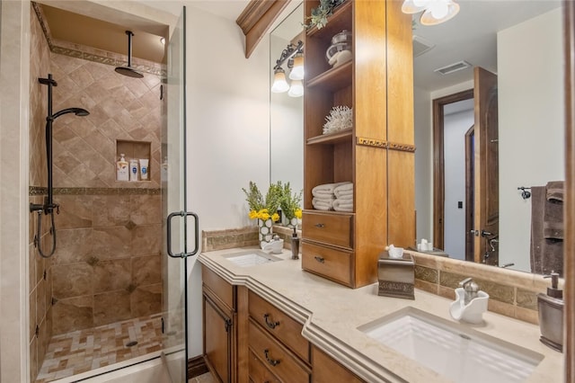 bathroom featuring double vanity, visible vents, a sink, and a stall shower