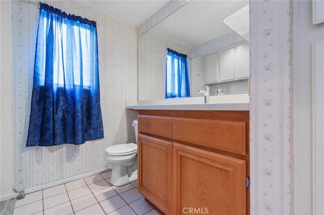 half bath with vanity, toilet, tile patterned floors, baseboards, and wallpapered walls