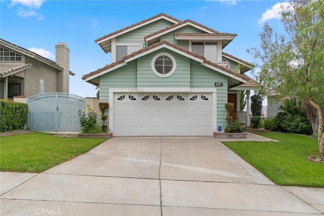 view of front of home featuring concrete driveway, a tile roof, a gate, and a front yard