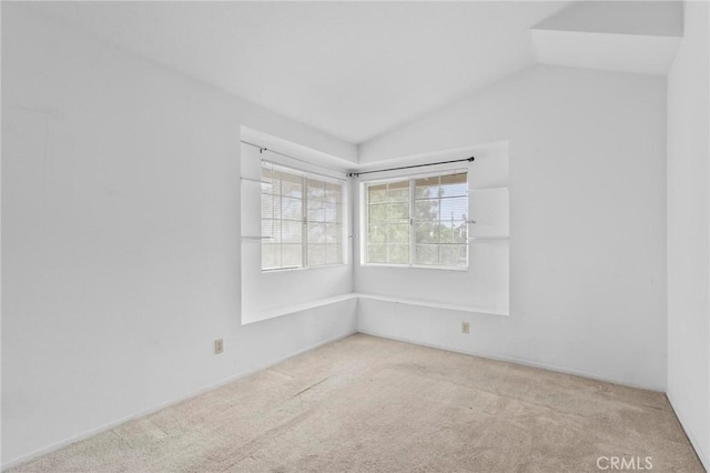 spare room featuring carpet floors and lofted ceiling