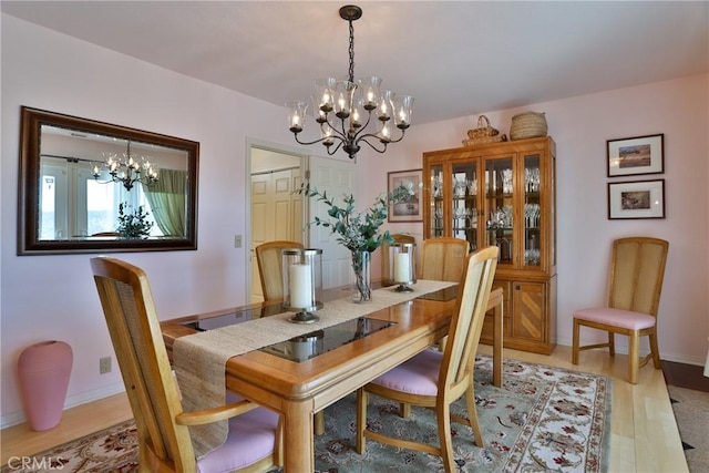 27720 St Bernard Ln, Lake Arrowhead, CA 92352 - dining space featuring baseboards, light wood finished floors, and a chandelier
