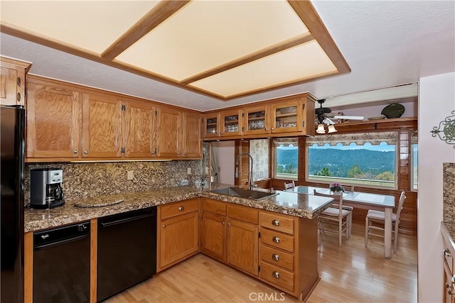 27720 St Bernard Ln, Lake Arrowhead, CA 92352 - kitchen with a sink, brown cabinetry, light wood-style flooring, a peninsula, and black appliances