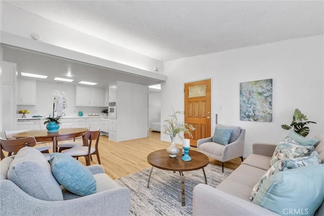 living room featuring light wood finished floors and a textured ceiling