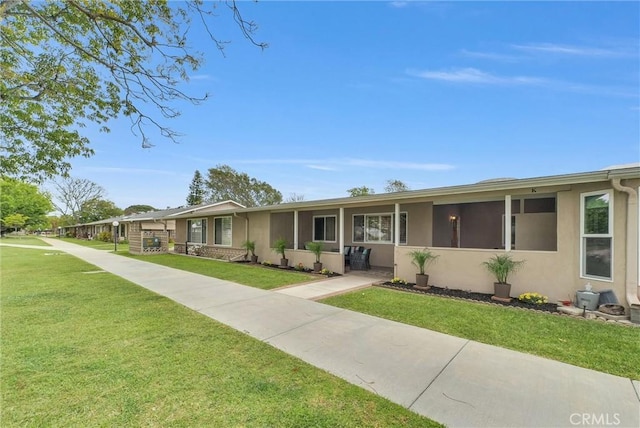 ranch-style house featuring a front yard and stucco siding
