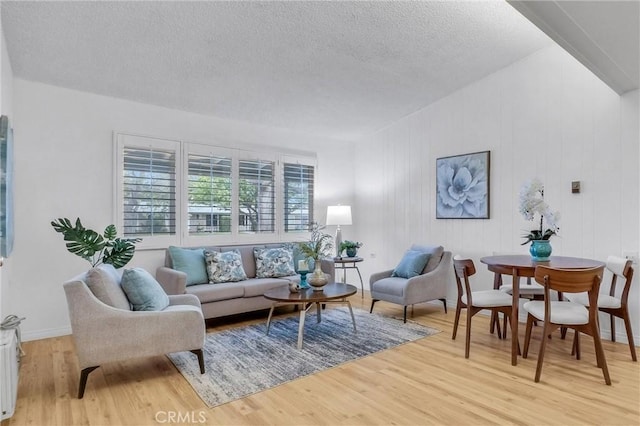 living area with light wood-style floors and a textured ceiling