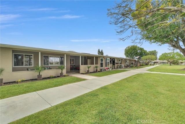 single story home with a front yard and stucco siding
