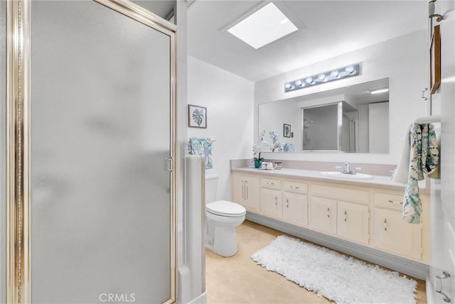 bathroom featuring double vanity, toilet, a sink, and a stall shower
