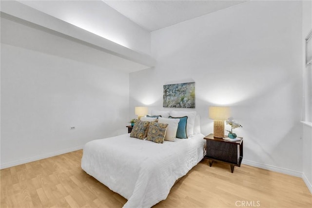 bedroom with baseboards and light wood finished floors
