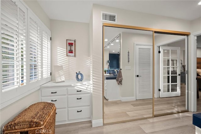 interior space with a sink, light wood-style flooring, and visible vents