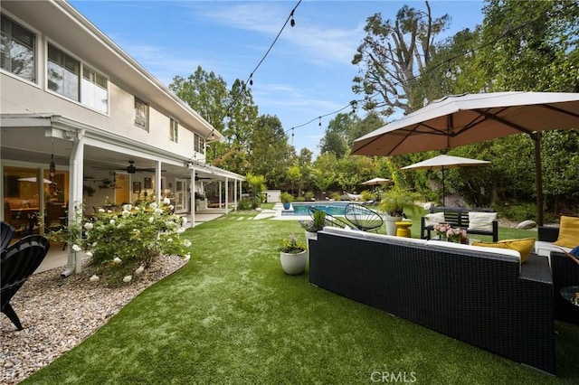 view of yard featuring an outdoor living space, a ceiling fan, a patio area, and an outdoor pool