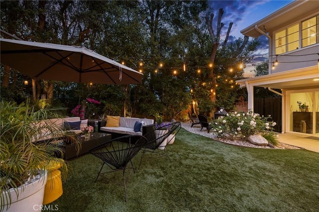 view of yard featuring an outdoor living space with a fire pit, a patio area, and fence