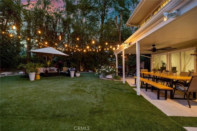 view of yard featuring an outdoor living space, ceiling fan, a patio area, and outdoor dining space