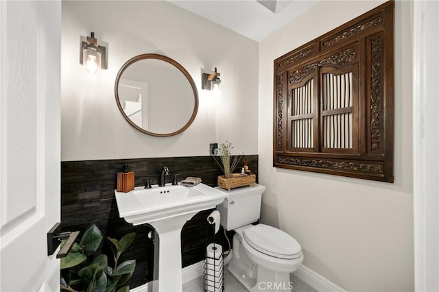 bathroom with baseboards, tile patterned flooring, toilet, and visible vents