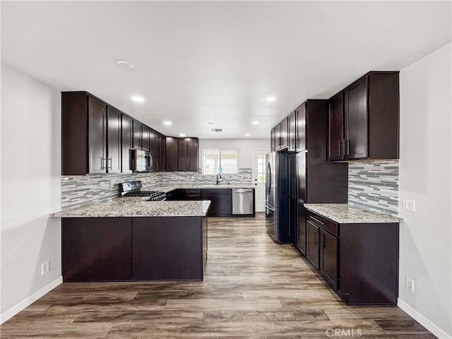 509 Kristi Ln, Blythe, CA 92225 - kitchen with backsplash, stainless steel appliances, wood finished floors, and dark brown cabinets