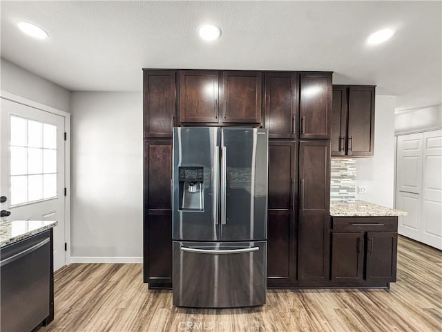 509 Kristi Ln, Blythe, CA 92225 - kitchen with light wood-style floors, dark brown cabinetry, light stone countertops, baseboards, and stainless steel fridge