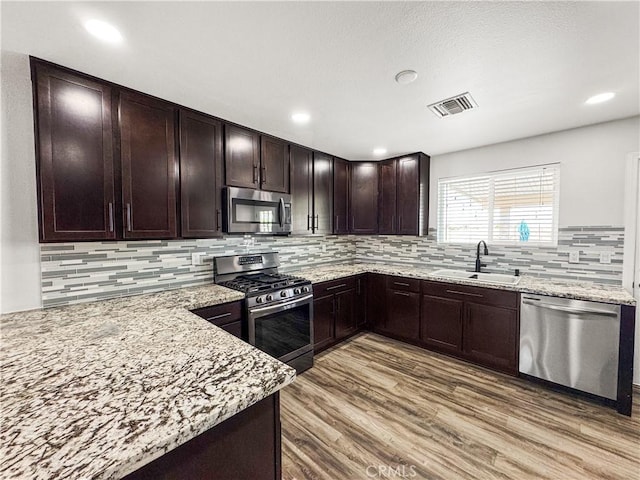 509 Kristi Ln, Blythe, CA 92225 - kitchen with visible vents, appliances with stainless steel finishes, light stone countertops, wood finished floors, and a sink