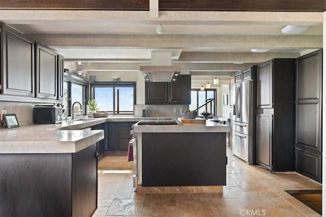 30140 Tuttle Ct, Tehachapi, CA 93561 - kitchen with beamed ceiling, stone tile flooring, stainless steel fridge, and plenty of natural light