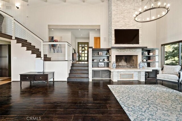 30140 Tuttle Ct, Tehachapi, CA 93561 - living area with a high ceiling, wood-type flooring, a fireplace with raised hearth, a chandelier, and stairway