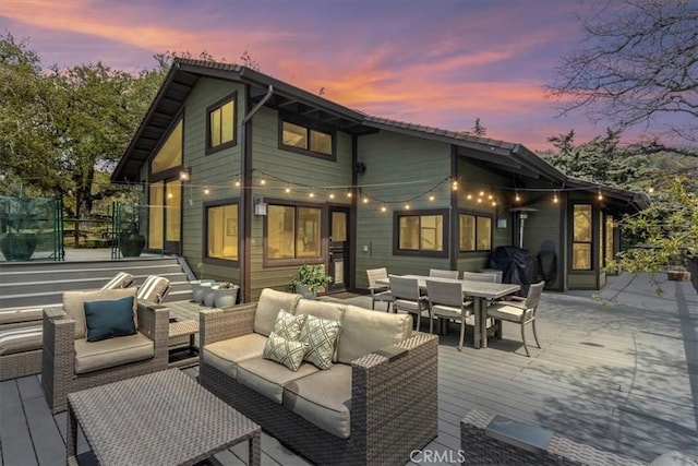 30140 Tuttle Ct, Tehachapi, CA 93561 - back of property at dusk with outdoor dining area, an outdoor hangout area, and a wooden deck
