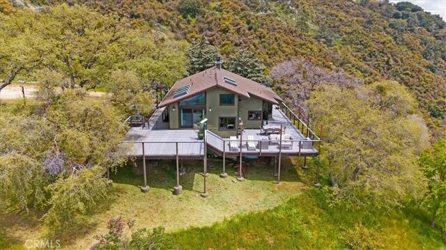 30140 Tuttle Ct, Tehachapi, CA 93561 - rear view of house with a view of trees, a wooden deck, and stairs